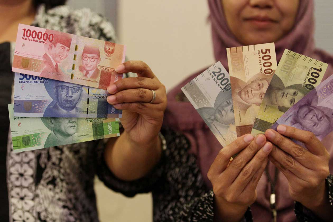 WAJAH PAHLAWAN INDONESIA: Petugas menunjukkan uang rupiah kertas tahun emisi 2016. Uang rupiah yang diluncurkan antara lain pecahan Rp 100.000, Rp 50.000, Rp 20.000, Rp 10.000, Rp 5.000, dan Rp 2.000.(GUNTUR AGA TIRTANA/RADAR JOGJA)