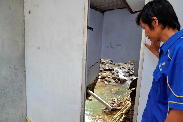 BOLONG : Pengelola PNPM Kaligesing Joko Surono menunjukkan gudang arsip yang ambrol beberapa waktu lalu. Ambrolnya talud menjadikan arus sungai terlihat dari dalam bangunan. (Budi Agung/Radar Jogja)
