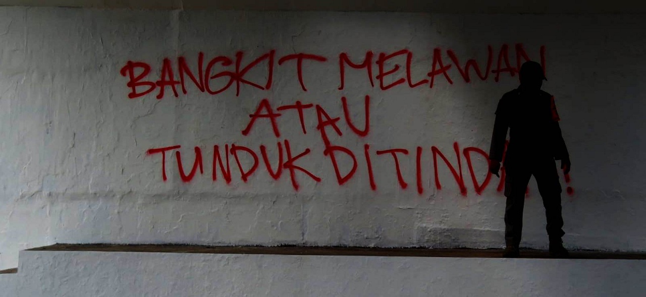 KEMBALI: Tulisan grafiti Bangkit Melawan atau Tunduk Ditindas. Tulisan cat semprot warna merah ini kembali dihapus oleh Satpol PP Kota Jogja, Senin siang (23/8) karena melanggar Perda DIJ Nomor 2 Tahun 2017. (DWI AGUS/RADAR JOGJA)