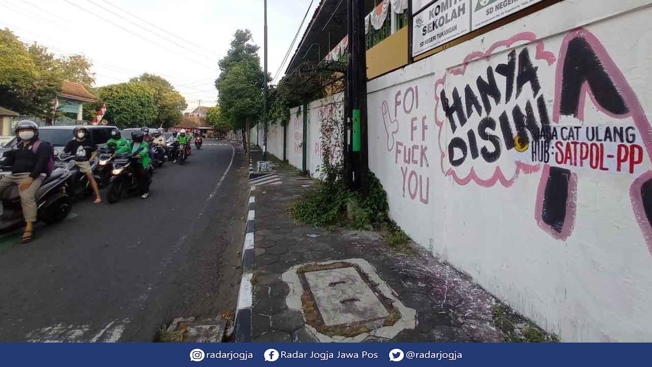 SAYANGKAN: Pihak Sekolah Dasar Negeri (SDN) Tukangan Pakualaman menyayangkan tulisan cat warna merah muda bermuatkan kritik dan umpatan dan satu visual yang menyerupai alat kelamin di tembok sisi luar menghadap jalan Suryopranoto. (DWI AGUS/RADAR JOGJA)