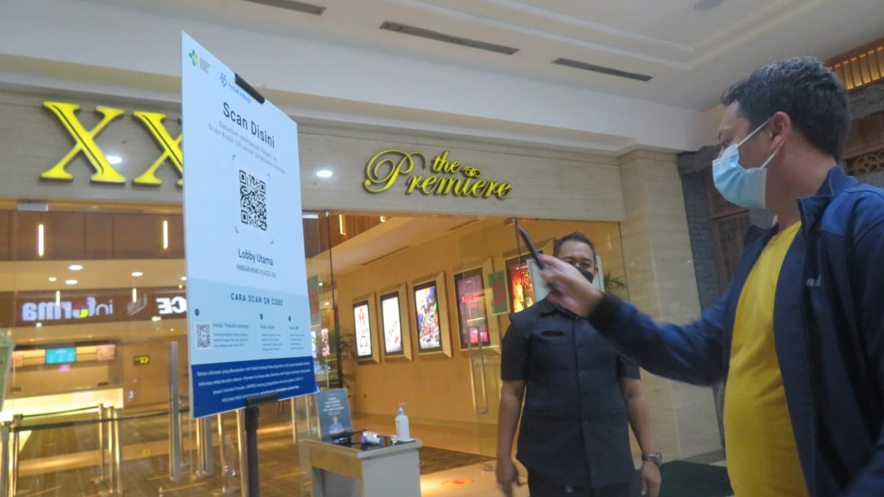 SEDANG: Calon Penonton Cinema XXI Plaza Ambarrukmo Jogjakarta sedang menscan QR Code Peduli Lindungi. Syarat Pengunjung yang bisa menonton harus sudah mendapat vaksin Covid-19 sebanyak 2 kali. (DWI AGUS/RADAR JOGJA)