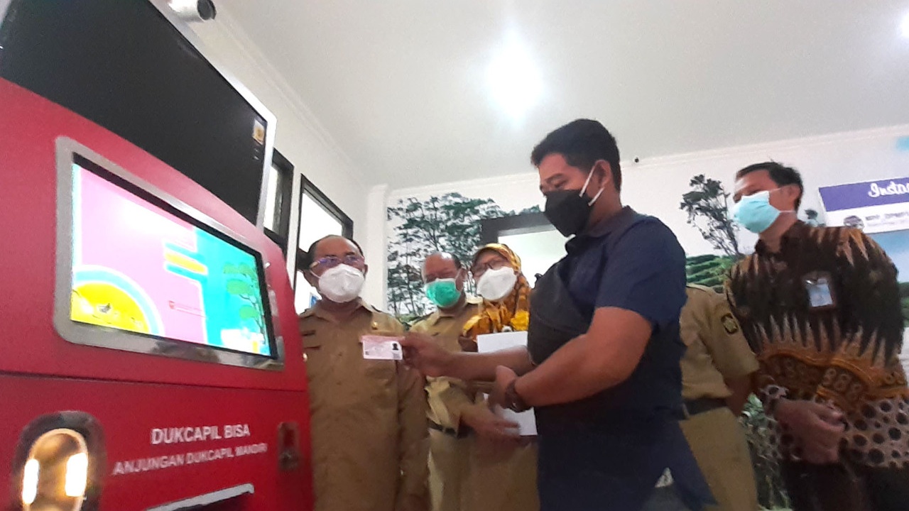 LAKUKAN: Galih Pitoyo warga Sentolo Kulon Progo sedang melakukan simulasi pencetakkan dokumen Kartu Identitas Anak (KIA), disaksikan Bupati Kulon Progo, Sutedjo Kepala Disdukcapil Kulon Progo. (DOKUMENTASI HUMAS PEMKAB KULONPROGO)