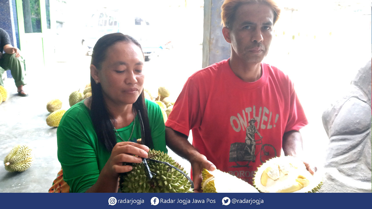 MUSIM DURIAN: Tohirin beserta istrinya, Narti sukses jadi juragan durian di dusunnya. Banyak pelanggan berdatangan untuk memborong duriannya.(Naila Nihayah/Radar Jogja)