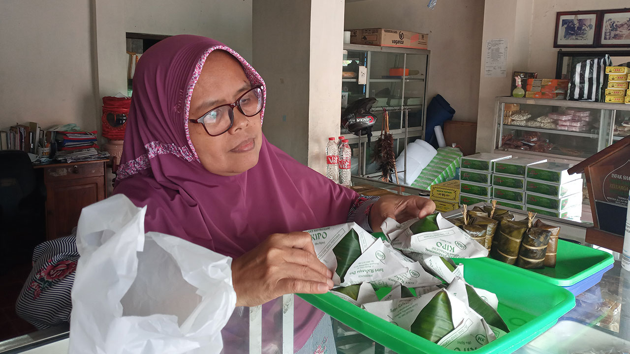 LAYANI PEMBELI: Istri Rahayu, pemilik toko Kue Kipo (Bu Djito) tengah melayani pembeli kemarin, (8/10). Kuenya dibandrol dengan harga Rp 2.500 per-bungkus.(Naila Nihayah/Radar Jogja)