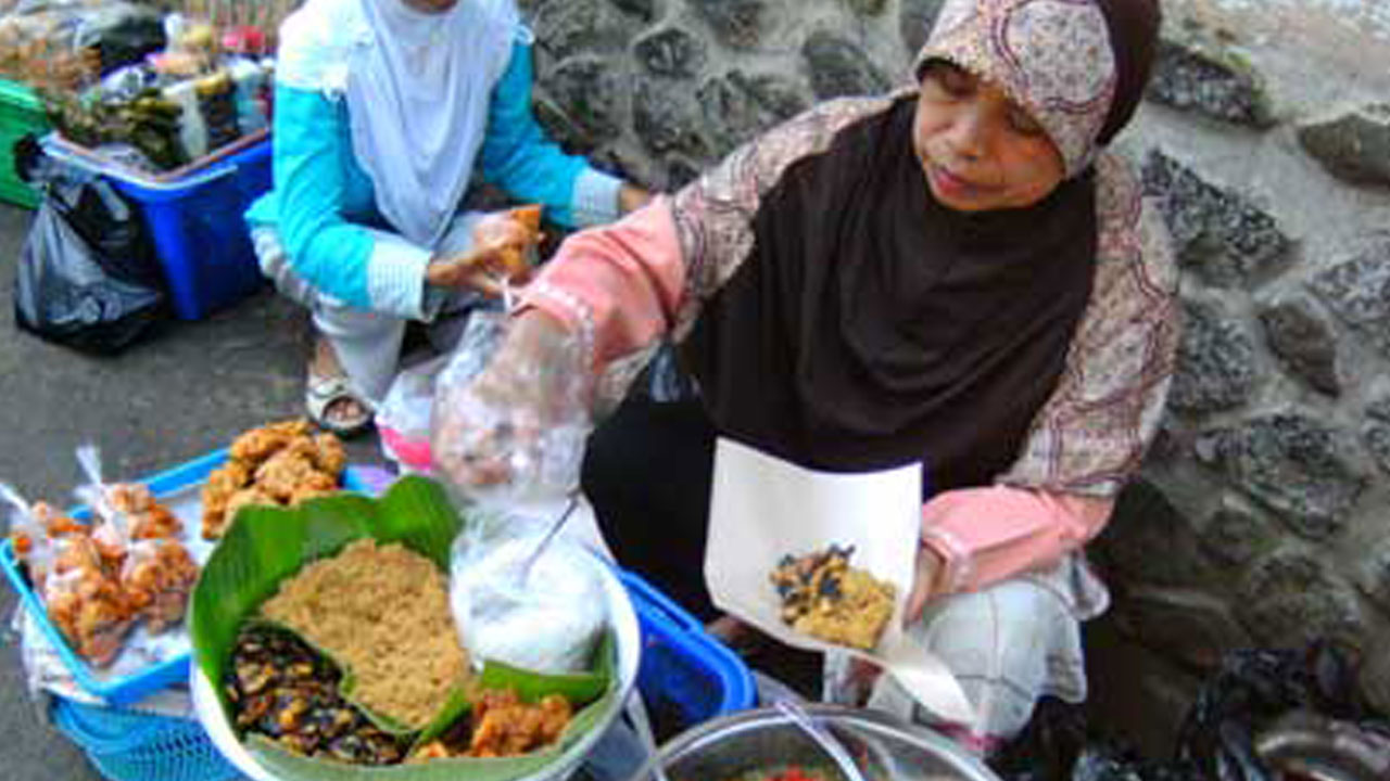LAYANI PEMBELI: Bu Sutinah, satu-satunya penjual buntil lumbu di Pasar Ngasem. Ia sudah berjualan sejak 14 tahun yang lalu.(Naila Nihayah/Radar Jogja)