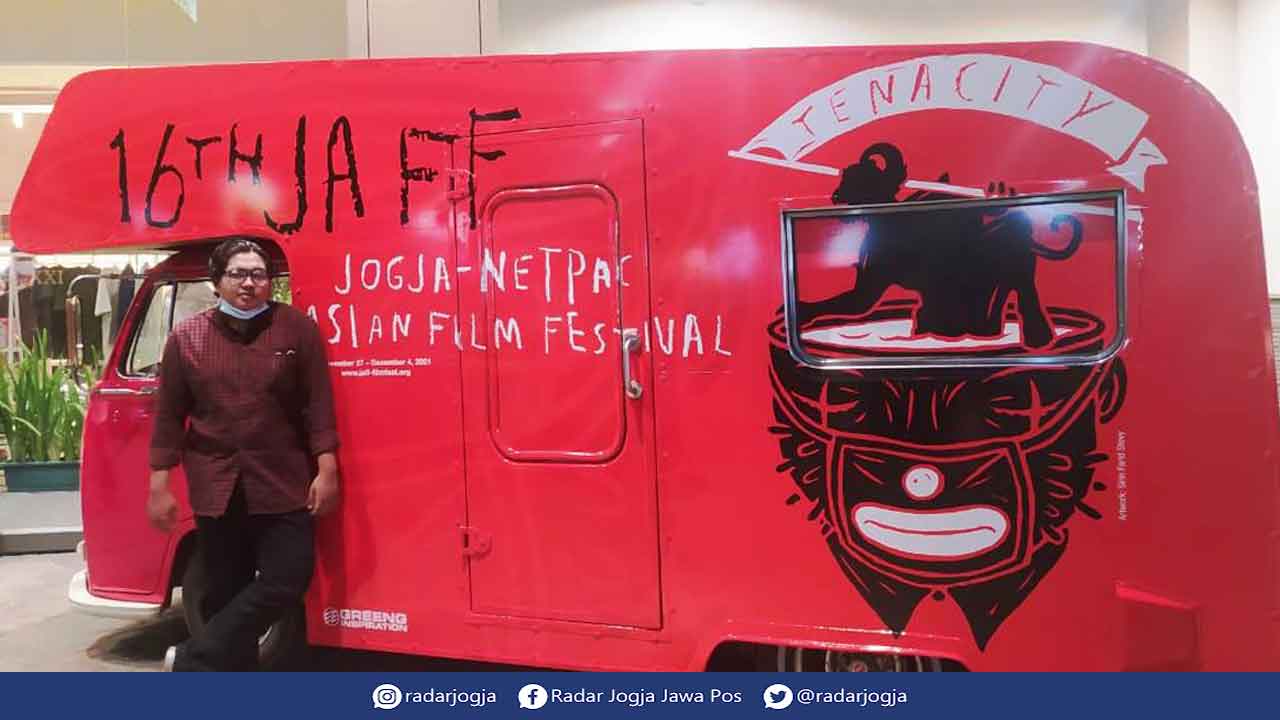 JAFF: Salah satu penggemar film berfoto di artwork JAFF ke-16 karya Sirin Farid Stevy. (ARYANDA AHMAD/RADAR JOGJA)