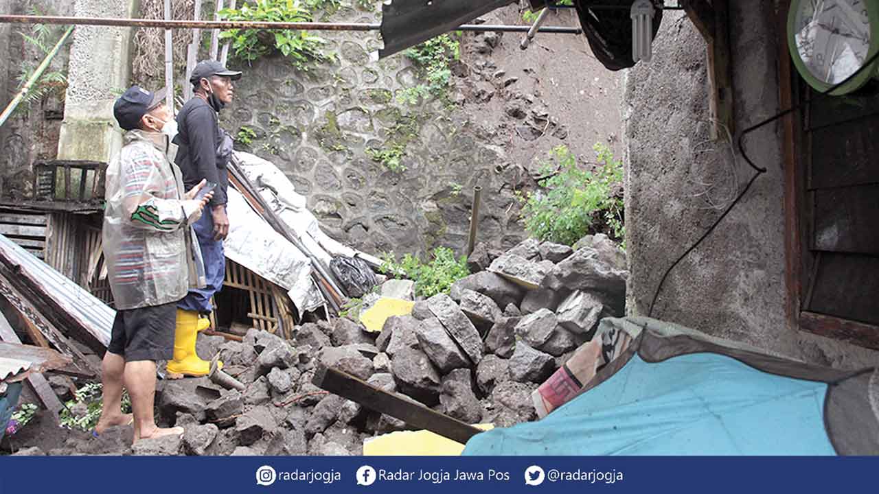 HANTAM RUMAH: Warga mengamati talud longsor yang menimpa bagian belakang rumah warga di Kampung Terban, Kelurahan Terban, Gondokusuman, Jogja, kemarin (11/11). Kejadian tersebut mengakibatkan penghuni rumah tertimpa reruntuhan dan mengalami patah kaki. (G