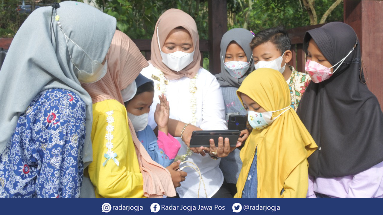 SERU : Bupati Sleman Kustini Sri Purnomo menunjukan serunya mengakses internet kepada anak-anak Padukuhan Sumberwatu, Sambirejo, Prambanan, Rabu (29/12). (ANNISA KARIN/RADAR JOGJA)