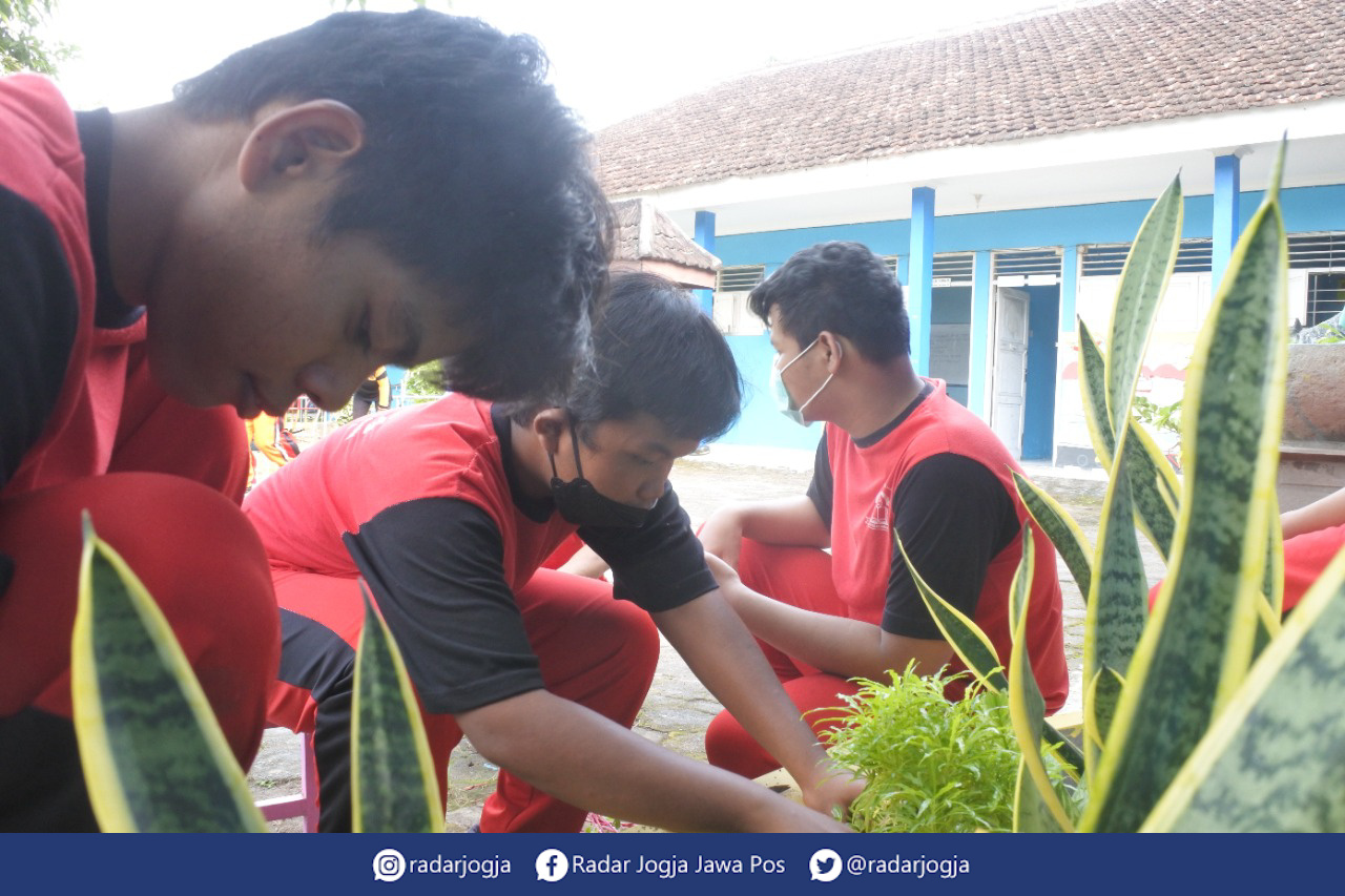 RERESIK : Para siswa SLB Tegar Harapan Sleman sedang kerja bakti dalam pelaksanan pembelajaran tatap muka (PTM) penuh, Kamis (6/1). (ANNISA KARIN/RADAR JOGJA)