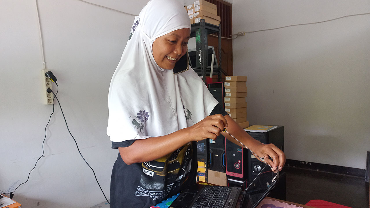 JELI: Nuri sembari menelepon, juga fokus memperbaiki layar laptop yang rusak di tempat usaha jasa servis laptop dan komputer, Padukuhan Ngemplak Caban, Tridadi, Sleman (31/1).(MEITIKA CANDRA LANTIVA/RADAR JOGJA)