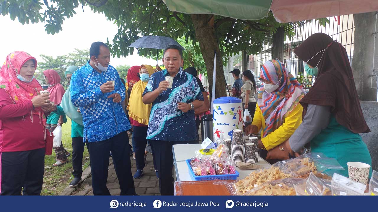 NIKMAT: Kepala Dinkop UKM Sleman Haris Martapa saat meninjau stan UMKM sembari mencicipi minuman wedang asem di acara Sunmor Lapangan Sendangadi, Mlati, Sleman, (23/1).(MEITIKA CANDRA LANTIVA/RADAR JOGJA)