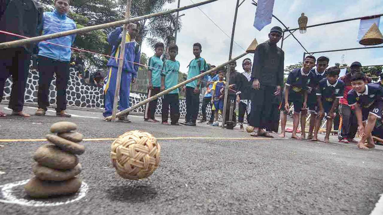 PAKAI BOLA PENJALIN: Selain kereweng dan bola kasti, permainan boi-boian ini juga bisa menggunakan batu untuk ditumpuk dan bola sepak takraw sebagai pelemparnya. (infopublik)