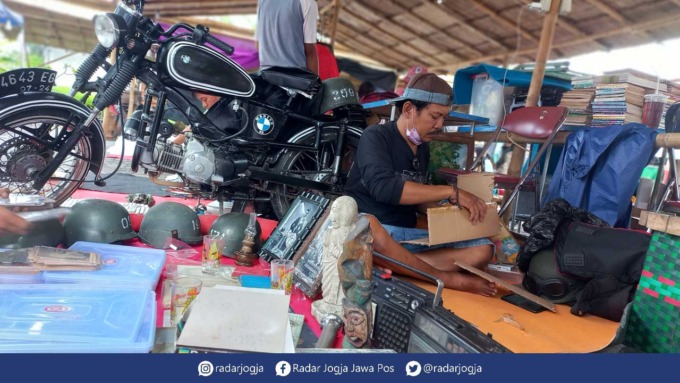 KOLEKSI PRIBADI : Dwinel bersama barang-barang antiknya yang dijual di event Pasar Kangen 2022. Kini hasil jualan barang antiknya bisa menjadi sumber penghasilan utama