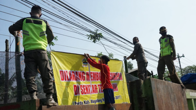 TUTUP PERMANEN: Forkopimcam Tempuran dan Satpol PP Kabupaten Magelang melakukan pembersihan sampah di TPS Setro dan memasang tanda larangan membuang sampah.(Nanang Febriyanto/Radar Jogja)