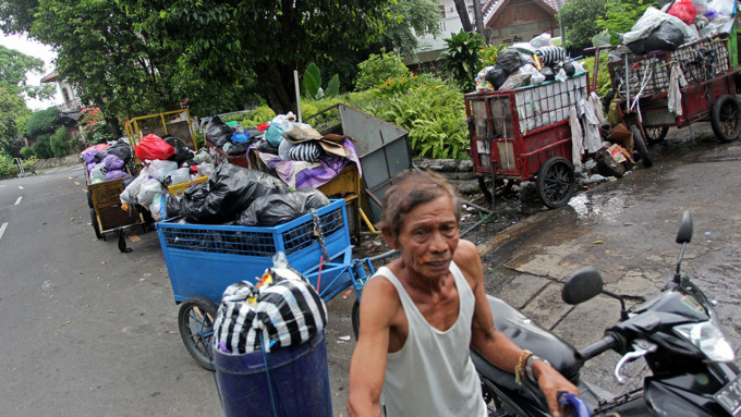 MENGAIS SAMPAH: Seorang warga mengais sampah makanan untuk pakan ternak babinya, di Depo Mandala, Kota Jogja, kemarin (8/5).(GUNTUR AGA TIRTANA/RADAR JOGJA)