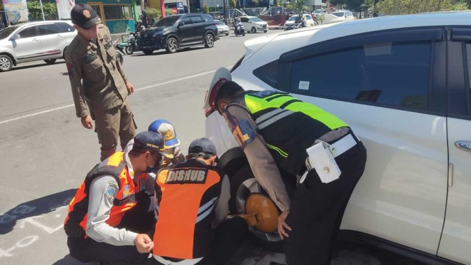 PENERTIBAN: Petugas gabungan dengan tegas menggembok kendaraan, khususnya roda empat yang parkir sembarangan. Terutama di zona terlarang.(ISTIMEWA)