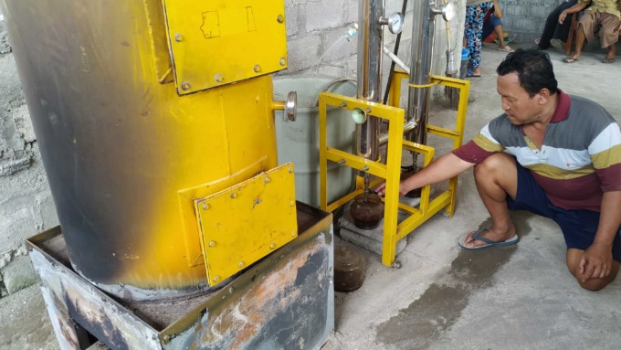 INOVATIF: Ketua Bank Sampah Gerbang Pilah Suratno saat meragakan alat pirolisis yang bisa mengubah sampah plastik menjadi minyak tanah (25/5).(IWAN NURWANTO/RADAR JOGJA )