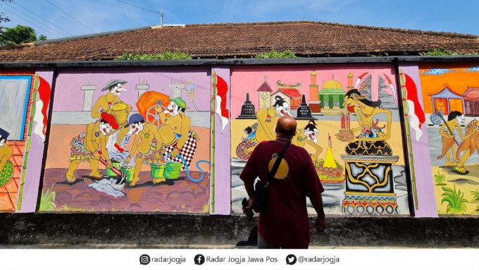 ARTISTIK: Saat masuk gang menuju Dusun Karang Watu, Desa Pucungrejo, Kecamatan Muntilan, disuguhi mural wayang di sisi tembok kiri dan lukisan para pahlawan di sisi kanan.(NAILA NIHAYAH/RADAR JOGJA)