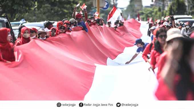 Peserta aksi yang tergabung dalam organisasi massa Pejuang Nusantara Indonesia Bersatu (PNIB) menggelar kirab bendera merah putih sepanjang 90x3 meter di kawasan Tugu, Jogja, Minggu (19/6). kegiatan itu dilaksanakan untuk menumbuh kembangkan jiwa nasional