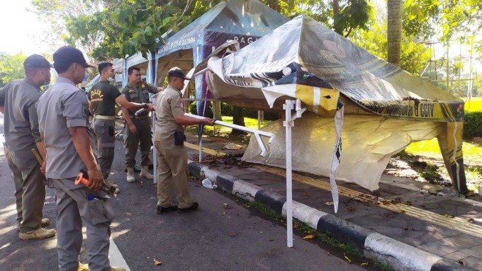 TEGAS: Petugas Satpol PP dan Dinas Perdagangan Kabupaten Kulonprogo membongkar tenda PKL di sisi barat Alwa Kulonprogo.(HENDRI UTOMO / RADAR JOGJA)