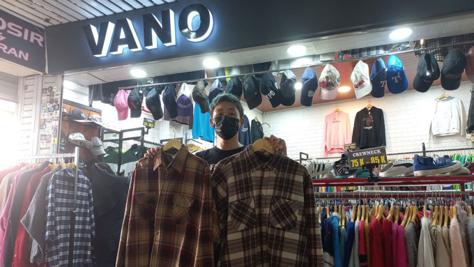 LARIS: Belga Bermawan, 30, pemilik Vano Thrift Shop, Pasar Beringharjo, Jogja, menunjukkan kemeja thrift flannel motif kotak-kotak saat ditemui Radar Jogja (1/7).(MEITIKA CANDRA LANTIVA/RADAR JOGJA)
