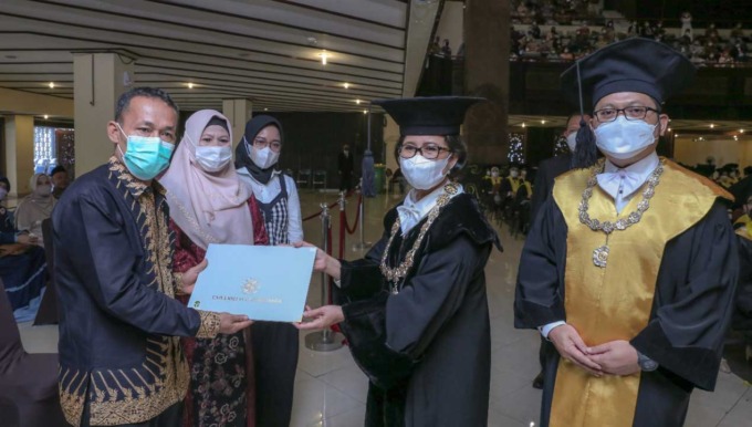 TERIMA IJAZAH : Ayah dari almarhumah Reni Sabrina, Rosewarzal saat menerima ijazah wisuda putrinya dalam prosesi wisuda Program Pascasarjana Periode IV 2021/2022 UGM, kemarin (20/7). Rektor UGM, Prof Ova Emilia menyerahkan langsung ijazah tersebut kepada