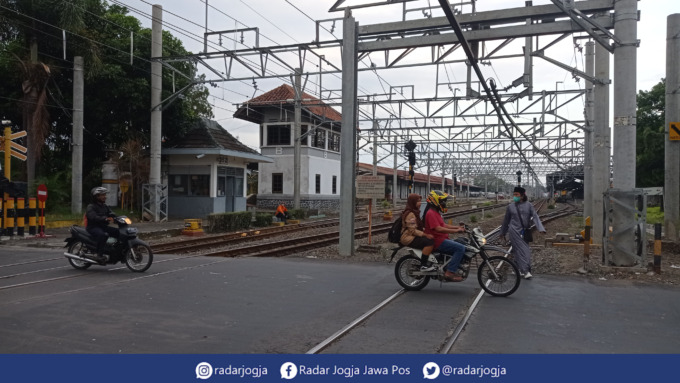 HATI-HATI : Warga tengah menyeberangi pintu perlintasan Stasiun Lempuyangan Kota Jogja, Jumat (19/8). (DWI AGUS/RADAR JOGJA)