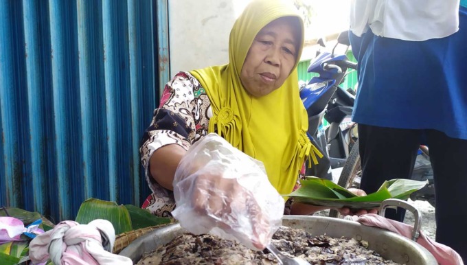 LARIS MANIS: Sumirah, 65, warga Padukuhan Kalimenur, Kalurahan Sukoreno, Kapanewon Sentolo, saat menjajakan tempe besengek di dekat Underpass di Kalurahan Kedungsari, Kapanewon Sentolo.(HENDRI UTOMO / RADAR JOGJA)