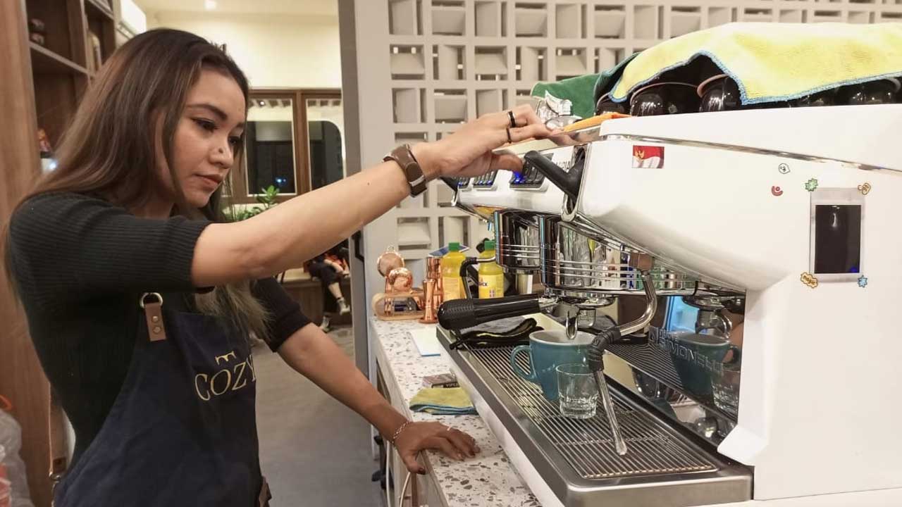 LAYANI KONSUMEN : Titi Mulyani, seorang barista di salah satu coffe shop di Kebumen begitu piawai meracik seduhan kopi sebelum dinikmati pembeli. (M Hafied/Radar Kebumen)