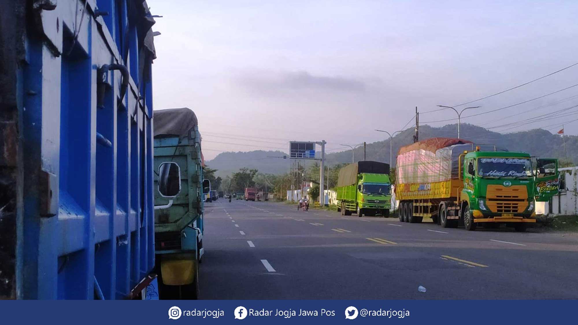 MINGGIR : Sejumlah truk bertonase tinggi rehat di perbatasan DIJ-Jateng tepatnya perbatasan Kecamatan Bagelen, Kabupaten Purworejo dan Kapanewon Temon, Kabupaten Kulonprogo, kemarin. (HENDRI UTOMO/RADAR JOGJA)