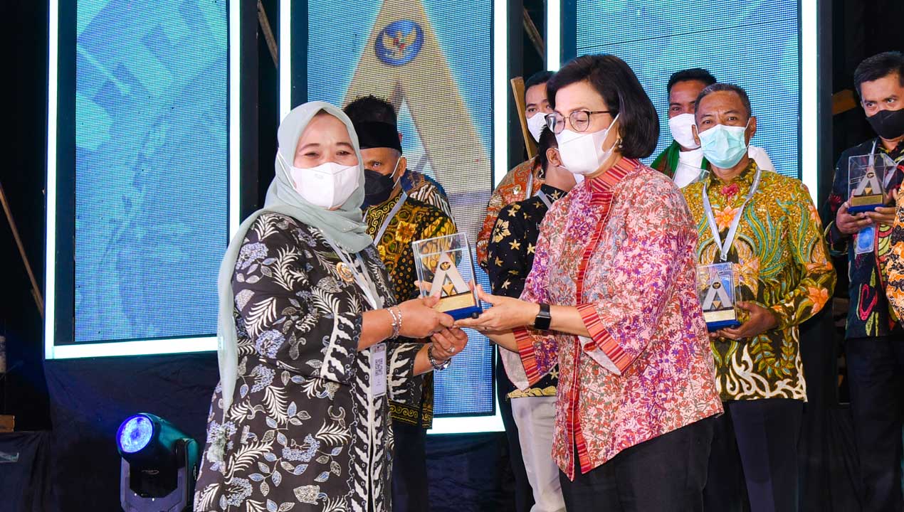 PRESTISIUS: Bupati Sleman Kustini Sri Purnomo (kiri) menerima penghargaan Pemerintah Republik Indonesia atas capaian opini WTP minimal 10 kali berturut-turut untuk laporan keuangan pemerintah daerah tahun 2012-2021. Penghargaan diserahkan oleh Menteri Keu