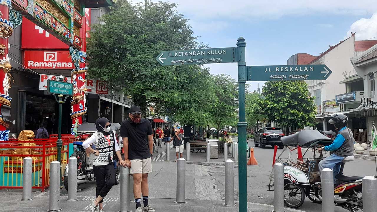 Wisatawan berfoto di sekitar jalan Malioboro saat bentor melintas.(RADAR JOGJA FILE)