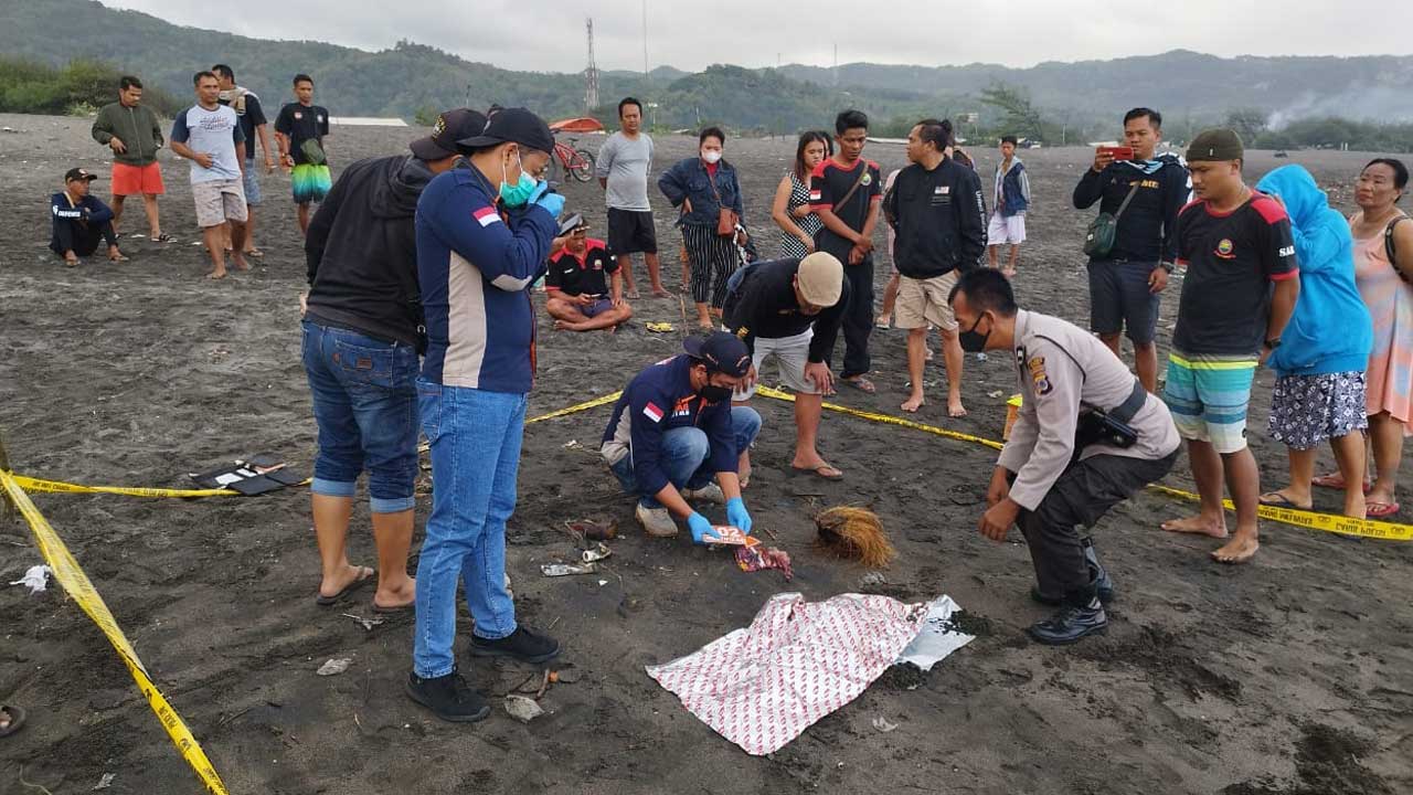 EVAKUASI: Petugas Polres Bantul saat melakukan olah kejadian tempat perkara penemuan jasad bayi di Pantai Parangkusumo kemarin (28/9).(DOKUMENTASI HUMAS POLRES BANTUL)