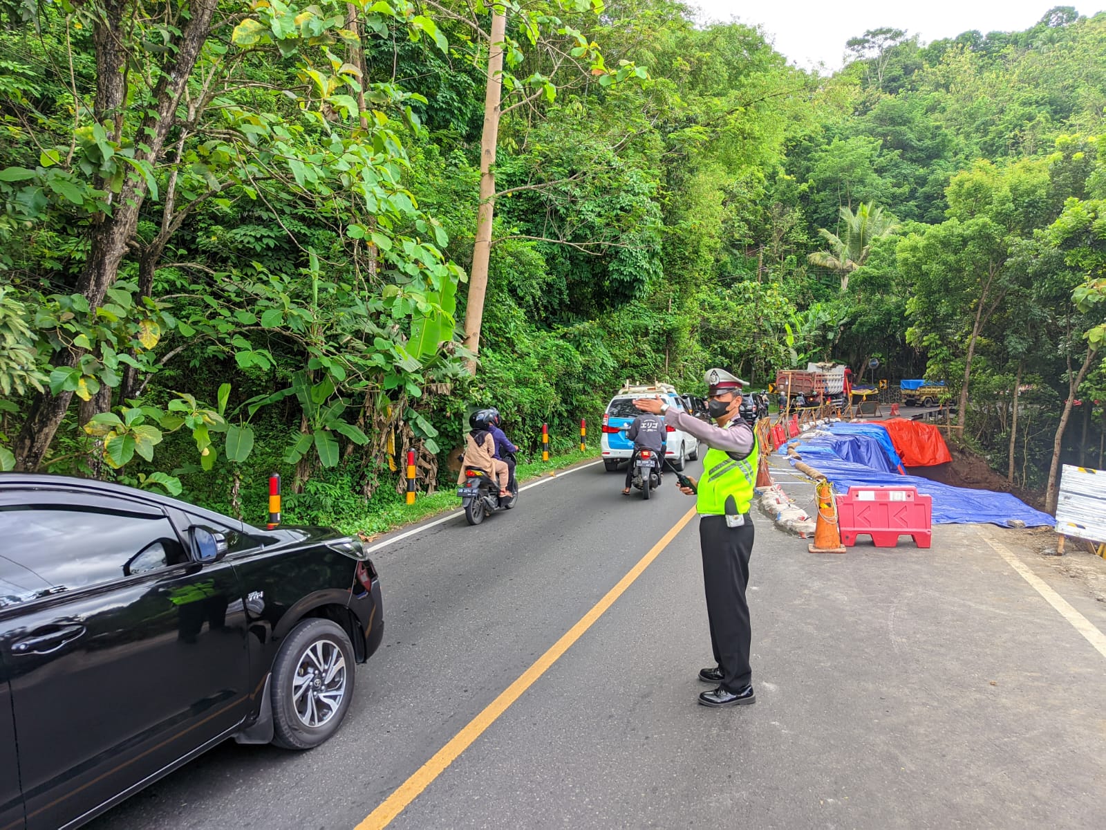 BUKA TUTUP : Personil Satlantas Polres Bantul melakukan rekayasa jalan kawasan Bukit Bintang akibat longsor, Senin (31/10). (SATLANTAS POLRES BANTUL for RADAR JOGJA)