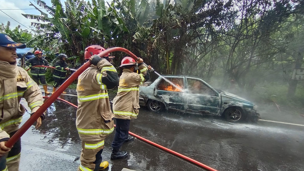 KOMPAK: Petugas gabungan saat berusaha memadamkan api yang bersumber dari sebuah mobil tanpa pemiliknya (12/10).(DOKUMENTASI SATPOL PP KOTA MAGELANG)