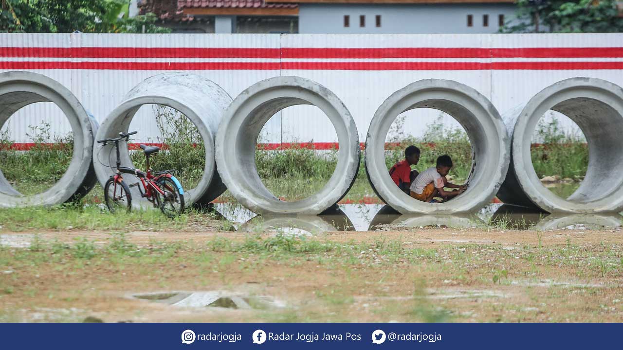 MULAI DIBANGUN: Anak-anak bermain di material proyek tol Jogja-Bawen, Sanggrahan, Tirtoadi, Mlati, Sleman, kemarin (18/10). Pembebasan lahan Tol Jogja YIA akan dimulai pada kuartal pertama 2023 dan ditargetkan selesai di kuartal kedua 2024. Agar ganti unt