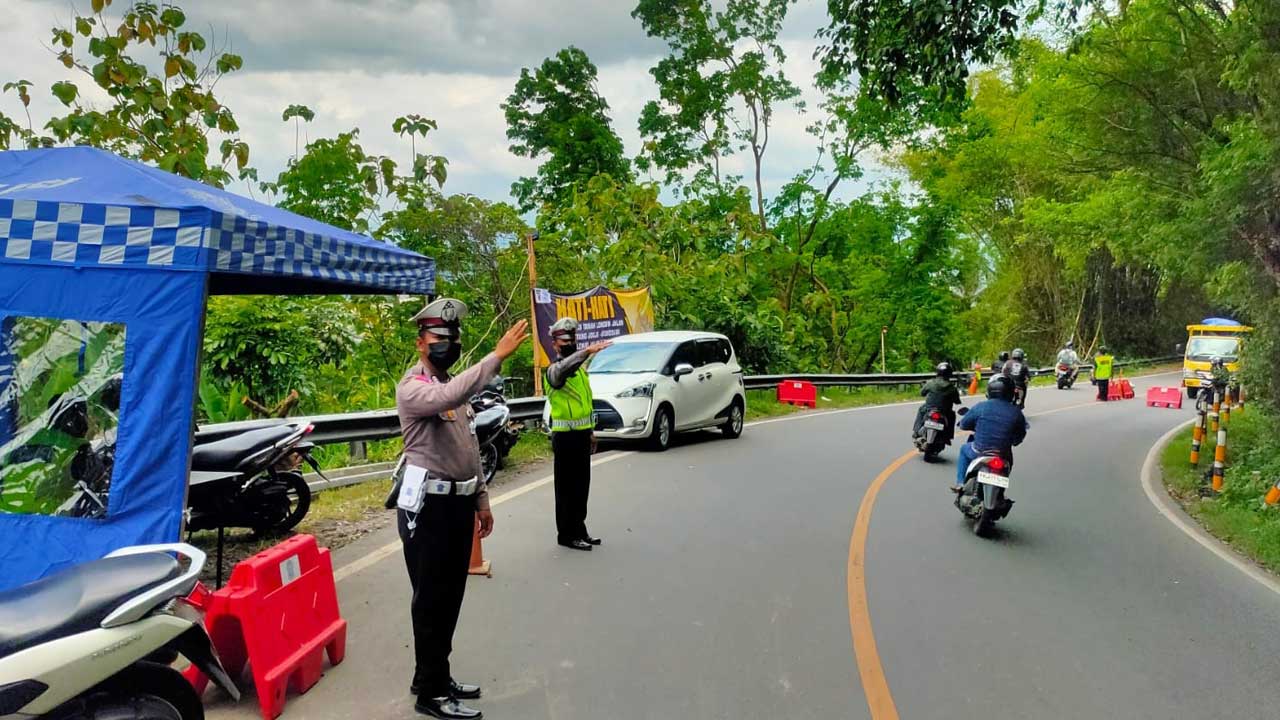SIAGA: Petugas Polsek Piyungan saat mengatur lalu lintas di pos pantau yang berada di lokasi tanah longsor Jalan Jogja-Wonosari Km.17 di Srimulyo,Piyungan, Bantul. Kehadiran pos tersebut diharapkan mampu melancarkan lalu lintas di titik tersebut.(DOKUMENT