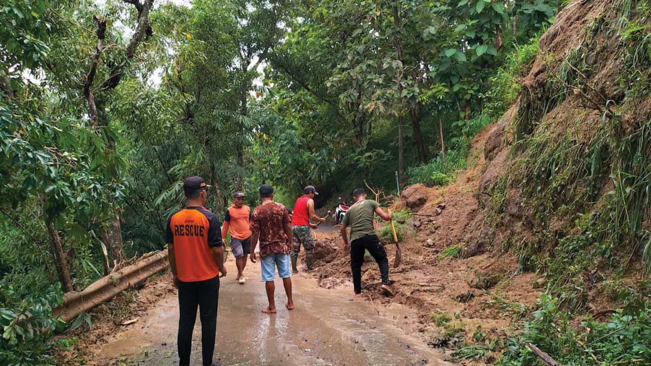 RAWAN – Para relawan melakukan pembersihan material longsor yang terjadi kemarin (13/12) dini hari di jalur menuju Pantai Siung, Kapanewon Tepus.(Foto Tim SAR untuk Radar Jogja)