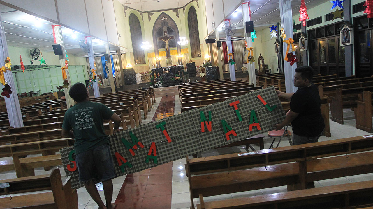 DIDESAIN: Orang Muda Katolik (OMK) saat memasang dekorasi Natal di Gereja Santo Aloysius Gonzaga, Mlati, Sleman Jumat malam (22/12). (GUNTUR AGA TIRTANA/RADAR JOGJA )