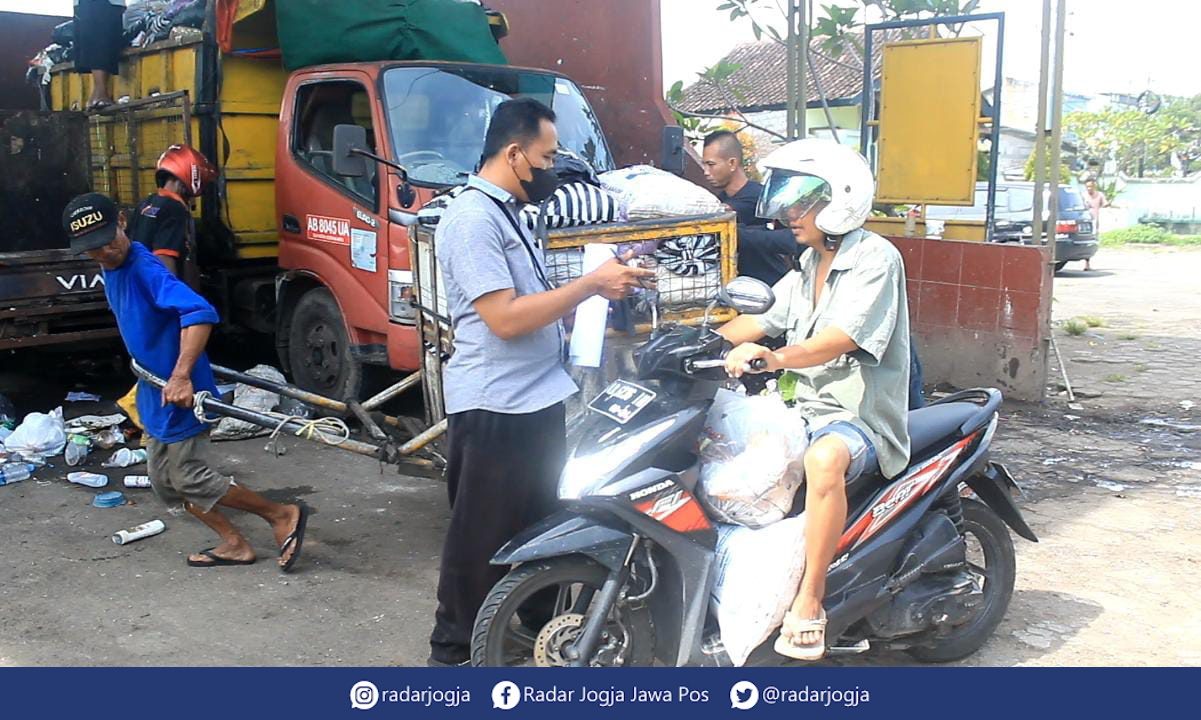 EDUKASI : Petugas DLH tengah menyampaikan edukasi mengenai pemilahan sampah kepada warga yang membuang sampah di Depo Sampah Utara Laya, Jalan Tompeyan, Tegalrejo, Kota Jogja, Senin (2/1). (ANNISSA KARIN/RADAR JOGJA)