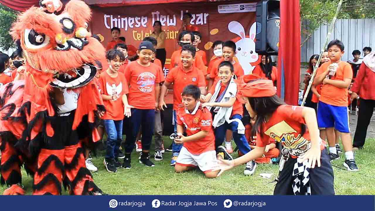 MERIAH: Para siswa Sekolah Mutiara Persada tengah berebut memberikan angpao untuk barongsai, Jumat (27/1). (ALFI ANNISA KARIN/RADAR JOGJA)