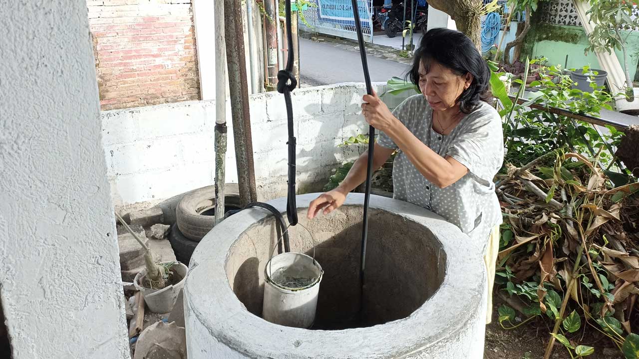 TETAP DIJAGA: Inti Retnowati menimba air dari sumur miliknya di Kampung Klitren Lor, Gondokusuman, Kota Jogja.(Gregorius Bramantyo/Radar Jogja)