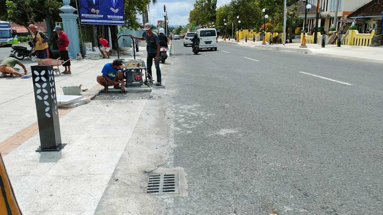 MASA PEMELIHARAAN – Sejumlah pekerja memperbaiki sejumlah fasilitas trotoar jalur Patung Tobong, Siyono, Playen (17/1).(GUNAWAN/RADAR JOGJA)