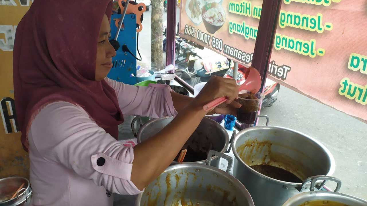 SEGAR: Penjual Jenang Senepo Catur Wulandari saat melayani pelanggan Jumat (27/1). Jenang ini terbuat dari tujuh jenis jenang, dan kerap ditemukan saat acara hajatan.(HENDRI UTOMO/RADAR JOGJA )