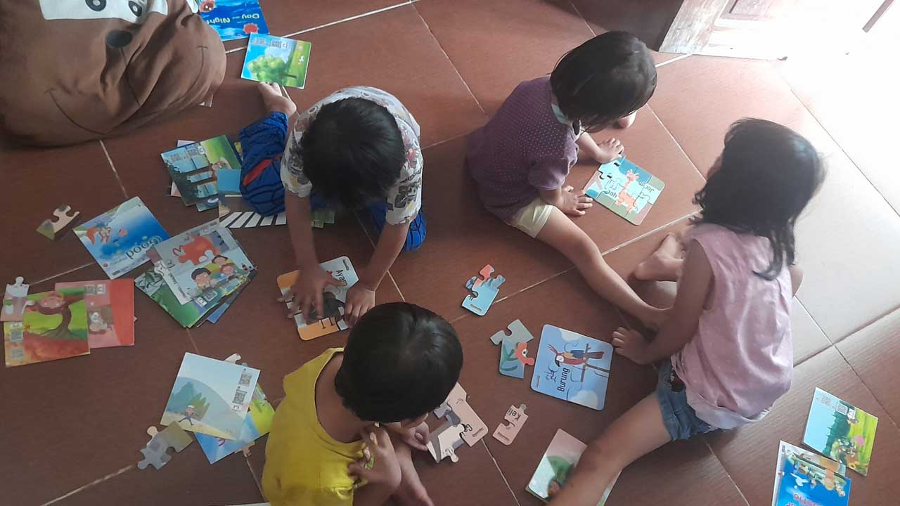 ILUSTRASI: Anak-anak sedang bermain puzzle dan membaca buku bersama.(SITI FATIMAH/RADAR JOGJA)