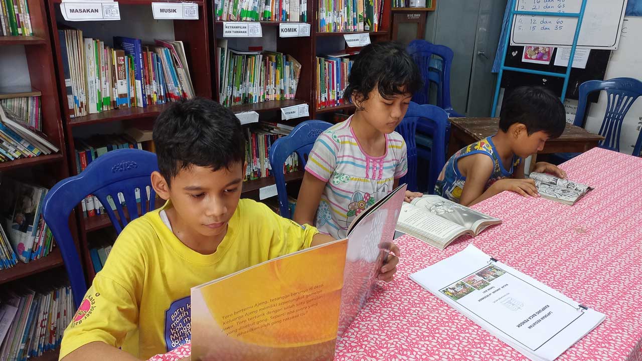 MENIKMATI BUKU : Nendra, Salwa dan Bima asik membaca buku Kampung Baca Pengok, yang terletak di Kampung Pengok  RW 12, Kalurahan Demangan, Gondokusuman, Jogja, (13/2).(MEITIKA CANDRA LANTIVA/RADAR JOGJA)