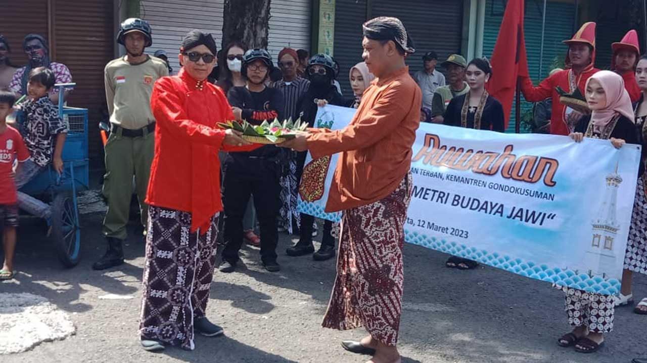 NYEKAR LELUHUR: Ketua Kampung Terban Harjono (kiri) menerima ubarampe kembang di sela acara Gelar Budaya Ruwah dan Kirab Gunungan Apem.(KUSNO S. UTOMO/RADAR JOGJA)