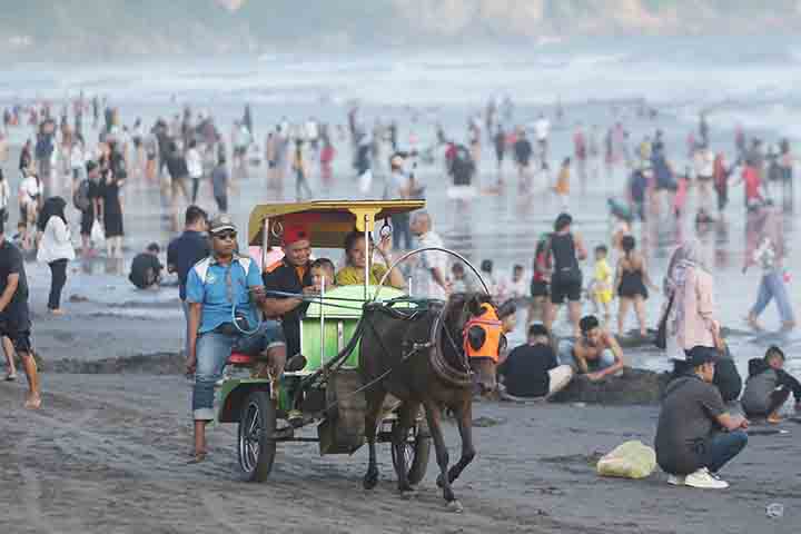 Wisatawan mengunjungi pantai Parangtritis saat libur lebaran 2023, Minggu (23/4). Jumlah kunjngan ke pantai parangtritis naik saat libur lebaran. Tercatat hingga sabtu (22/4) kunjungan sebanyak 6.378 orang (foto: elang kharisma dewangga).