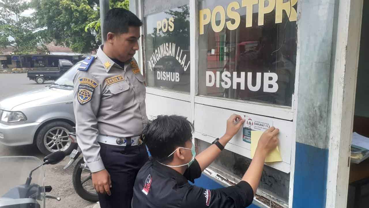 SOSIALISASI: Pegawai Diskominfo Kabupaten Magelang melakukan sosialisasi dengan menempel stiker call center 112 Kabupaten Magelang di ruang public. Diskominfo Kabupaten Magelang