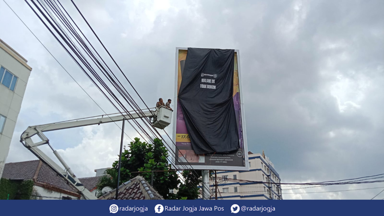 ILEGAL : Penutupan reklame tak berizin di Jalan Pasar Kembang oleh Satpol PP Kota Jogja, Selasa (9/5). (ANNISSA KARIN/RADAR JOGJA)